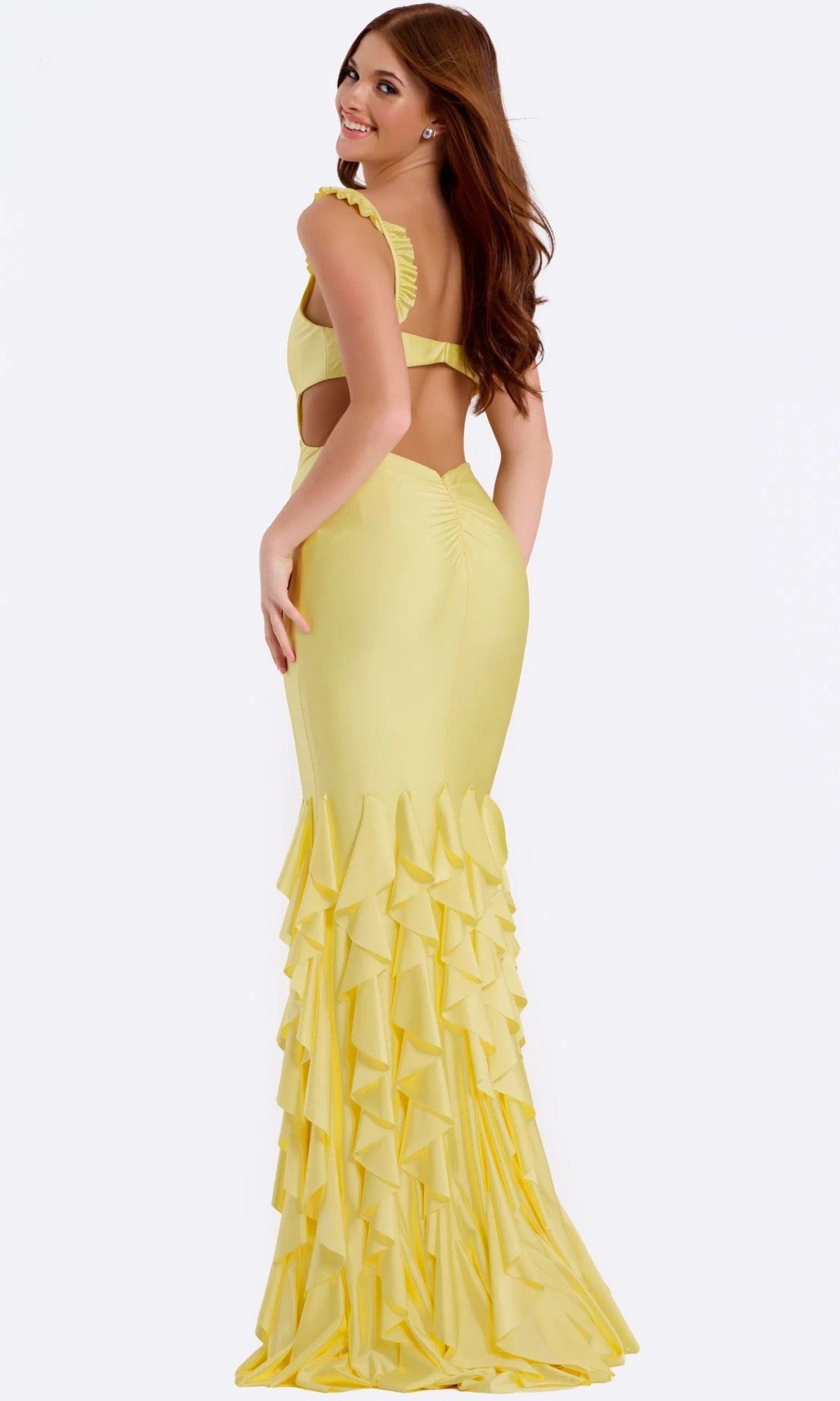 Woman in a yellow Jovani 49897 long prom dress with a ruffle tiered mermaid skirt, standing and looking over her shoulder against a plain background.